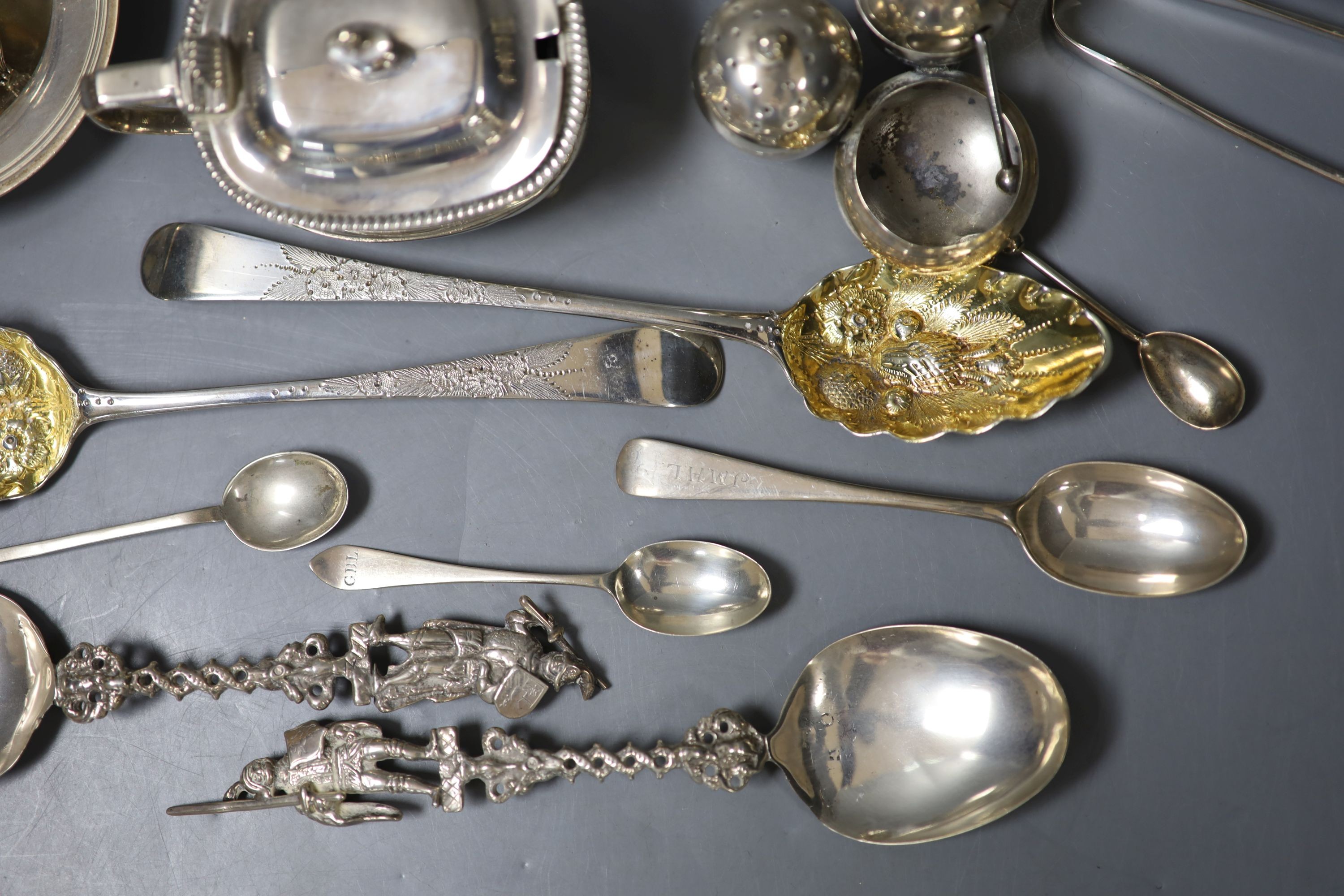 A group of small silver including a Georgian silver mustard, marks rubbed, a pair of Georgian silver berry spoons, two continental spoons, a small Victorian silver cruet stand, a tea strainer on stand, napkin ring, small